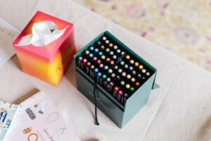 Box of vibrant markers used for drawing and creative projects.