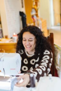 Woman learning basic sewing techniques during a hands-on workshop