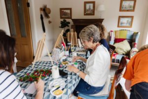 Group of women painting side-by-side during a creative workshop