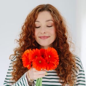 Manon, co-founder of WeSpark, pictured with some colourful flowers
